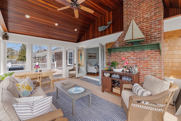 Spacious sunroom with vaulted mahogany ceilings and dining table.