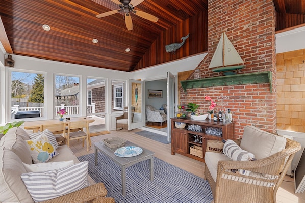 Spacious sunroom with vaulted mahogany ceilings and dining table.