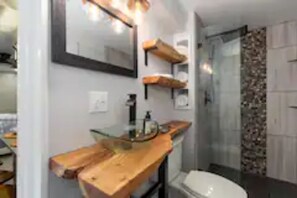 Lower level bath with custom live edge countertop, rainfall shower, blow dryer