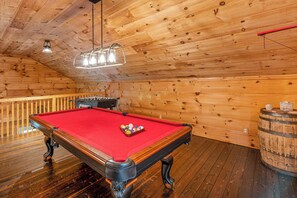 Cabin Fun Starts Here – Enjoy friendly competition in your private game room featuring a rich red felt pool table, foosball, and rustic vibes that keep the good times rolling.