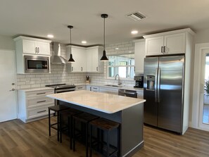 Newly remodeled, fully stocked kitchen with stainless steel appliances.