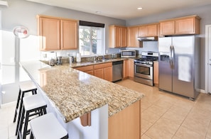 The kitchen is equipped with stainless steel appliances and cookware