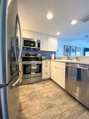 Updated kitchen featuring stainless appliances and quartz countertops.