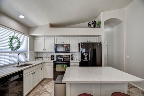 Kitchen equipped with utensils/appliances/condiments for cooking & serving meals