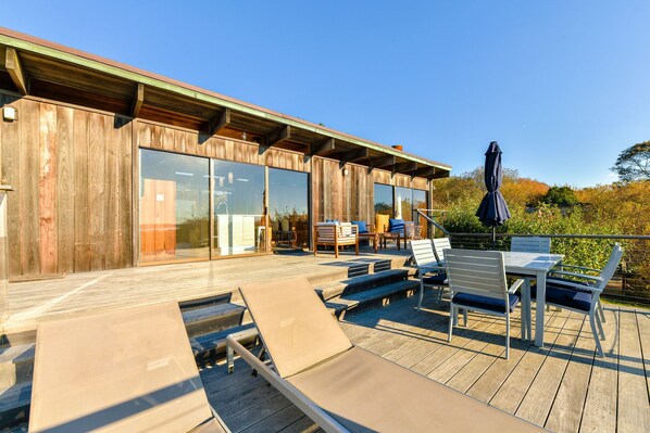 Expansive sun deck with dining set, loungers, and seating area.