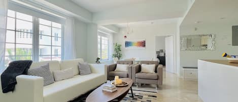 Large and comfortable living room with sofa, armchairs, kitchen and dining table