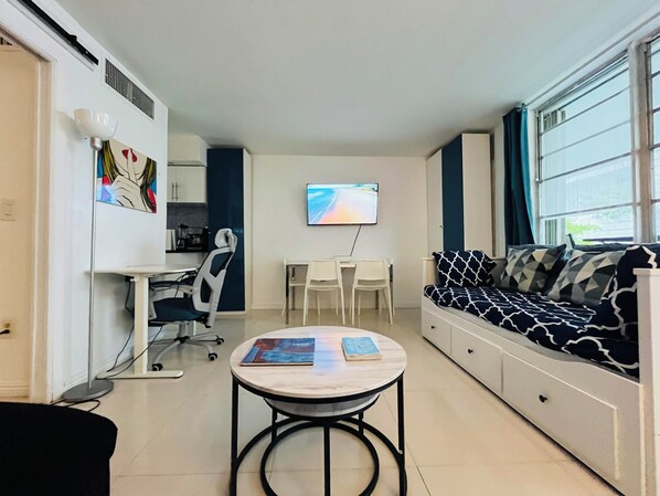 Living Room with dinning table, 2 sofas that can turn into beds and desk.