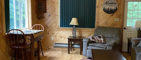 Living room, small dining table with two stools, couch and recliner. 