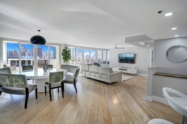 Dining area and living room, balcony access, views of Miami skyline