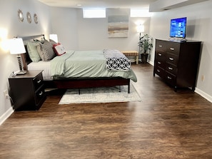 Spacious bedroom with nightstands and big dresser for extra storage.