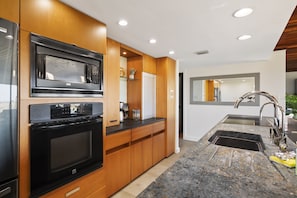 Kitchen is stocked with pots, pans, cookie sheets, crockpot, coffee maker, dishes, wine glasses, and more!