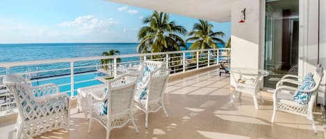 Tropical trees, a sparkling ocean, and comfy seating - a combo for a perfect stay!