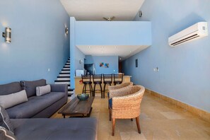 Open layout living area and kitchen, with stairs leading to loft bedroom