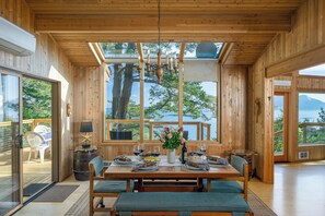 Dining under the trees and stars with an open kitchen and windows all around.