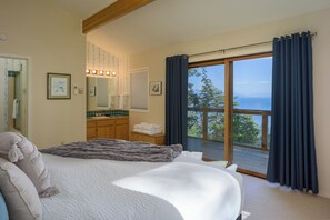 The main bedroom with a king bed and private deck outside.