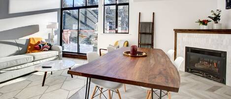 Modern scandinavian dining chairs paired with a beautiful wood table placed near the fireplace.