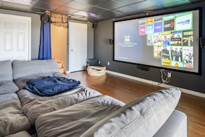 Home theater room with surround sound and comfy lounge couch.