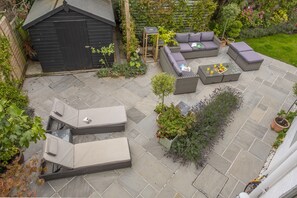 Thainstone House, Brancaster: Patio area with outdoor furniture and colourful planting