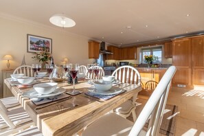 Saltings House, Ringstead: Dining area with well-equipped kitchen beyond