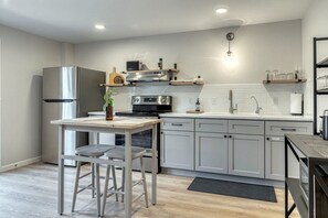 Kitchen area with pots, pans, plates, utensils and glasses