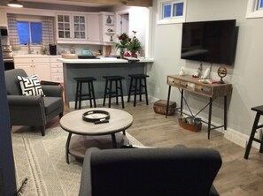 Living room with kitchen view. Island seating, Smart TV and open feel. 