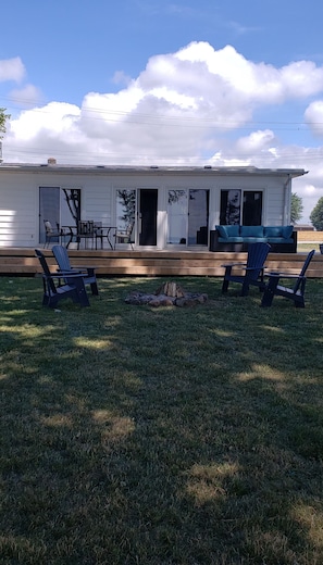 Deck with BBQ, dining table set and patio lounge furniture.