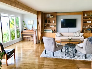 Wood floors and water views in the living room flow into kitchen and dining area