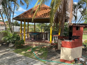 The outdoor gazebo with bar, bar stools, and sink.