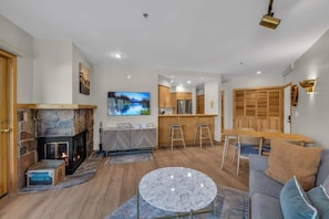 The view over the charming stone hearth wood fireplace and kitchen bar.