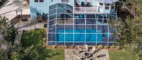 Experience ultimate outdoor relaxation with our screened pool, fire pit, and fenced yard from a stunning aerial perspective.