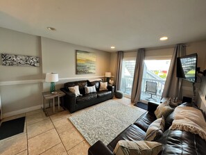 Living room open to the porch, which overlooks the pool.