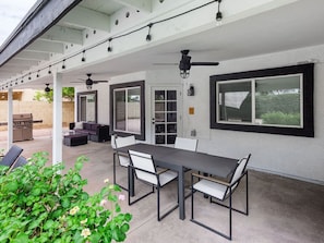Spacious backyard with a private pool, sun loungers, BBQ, covered patio, outdoor dining, seating area, and corn hole!