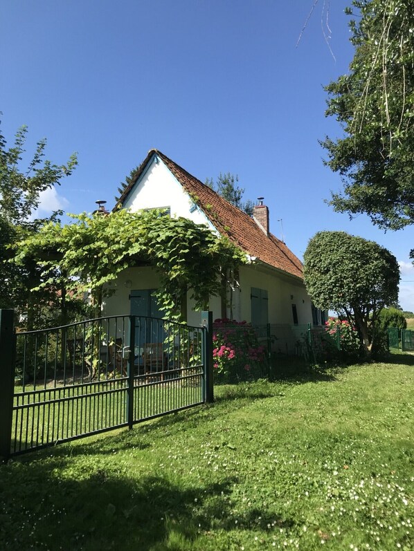 Vue arrière de la maison avec son joli jardin clôturé et portail fermable à clé