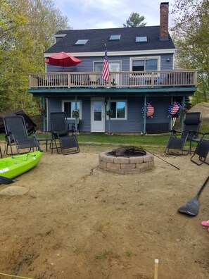 In-ground fire pit, chairs and back side view of home