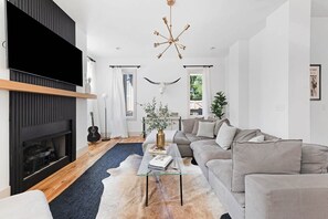 The stylish living room features an oversized sectional couch, providing ample seating and a comfortable space for relaxation and entertaining.