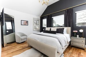 The spacious second-floor master suite features a king bed and a large en-suite bathroom, offering comfort and luxury for a relaxing stay.
