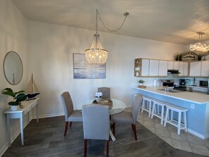 Spacious eating area with dining table and extra seats at the counter.