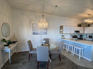 Spacious eating area with dining table and extra seats at the counter.