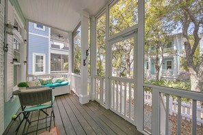 The Screened Front Porch faces lit trees that glisten like stars at night.