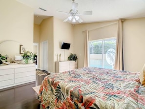 - Spacious master suite with floral bedding and soft neutral tones throughout
- Direct access to the pool lets you step outside for a morning swim or evening breeze
- Elegant dressers, mounted TV, and ceiling fan ensure comfort and convenience