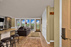 Living room leads to balcony and Murphy bed is tucked in the wall.