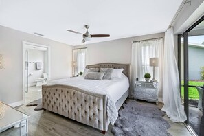 Luxurious owner’s suite with custom sliding doors opening to the pool area. This beautiful bedroom is filled with natural light, offering a peaceful and relaxing escape.