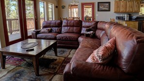 The living area features a large sectional focused on the woodburning fireplace and large screen with Dish TV.