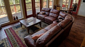 The living area features a large sectional focused on the woodburning fireplace and large screen with Dish TV.