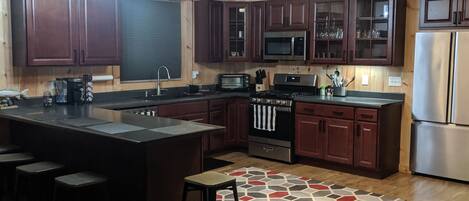 Large kitchen with a large counter for seating. 
