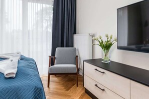 Living area with a double bed, TV, dining area and exit to the balcony