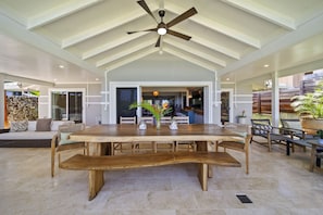 Spacious lanai with fans and seating, perfect for island-style dinners.