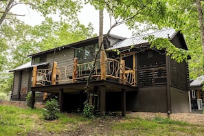 The Crooked Tree Cabin has a screened in porch with day bed and rockers and an uncovered porch with picnic table and grill. 