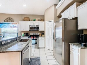 - Sleek and fully equipped kitchen with modern stainless steel appliances throughout
- Granite countertops and white cabinetry add a clean, upscale touch
- Plenty of room to cook, prep, and enjoy meals with the whole group