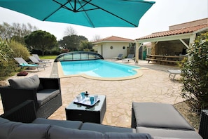 terrasse ensoleillée avec vue sur la piscine